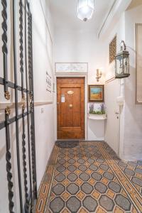 un couloir avec une porte en bois et du carrelage. dans l'établissement Relais & Maison Grand Tour, à Florence
