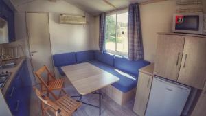 a small kitchen with a table and a blue couch at Camping Prima in Týn nad Vltavou