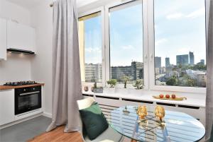 a kitchen with a glass table in front of a window at Rental Apartments Smolna in Warsaw