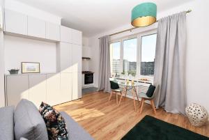 een woonkamer met een bank en een tafel met stoelen bij Rental Apartments Smolna in Warschau