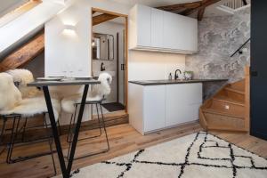 a kitchen with white cabinets and a table and stools at Studio74 in Annecy +5 photos