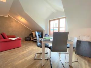 a living room with a table and a red couch at Ferienwohnung Denise in Rötz