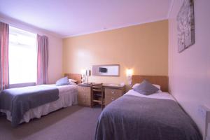 Postel nebo postele na pokoji v ubytování Pinegrove Hotel