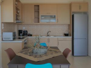 eine Küche mit einem Tisch mit Stühlen und einem Kühlschrank in der Unterkunft Haravgi 3 Bedrooms Villa in Agia Triada