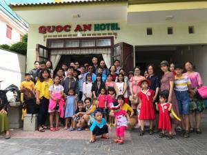 a group of people posing for a picture in front of a hotel at Quoc An Hotel in Long Hai