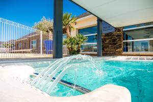 a pool with a water fountain in front of a building at M&V Resort Camping in Langrune-sur-Mer