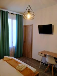 une chambre avec un lit, un bureau et une télévision dans l'établissement AL CIVICO 1 APARTMENTS, à Trapani