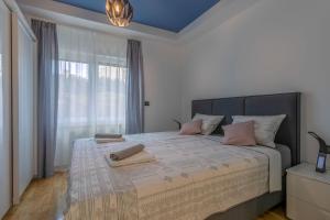 una camera da letto con un grande letto con una grande finestra di Arena Blue Dream - modern apartment with terrace a Pola (Pula)