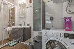 a bathroom with a washing machine and a sink at Arena Blue Dream - modern apartment with terrace in Pula