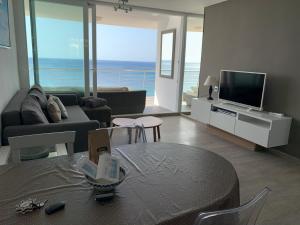 sala de estar con sofá, mesa y TV en Sea front, design, Air Conditioning, heating, First floor, 4beds, en Moraira