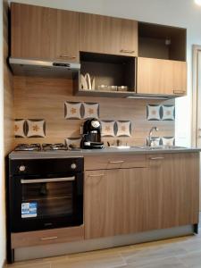 une cuisine avec une cuisinière et un évier dans l'établissement AL CIVICO 1 APARTMENTS, à Trapani