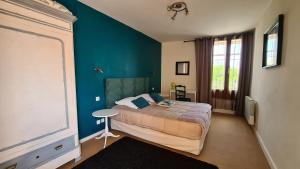 a bedroom with a bed and a blue wall at ALYSA in Parthenay