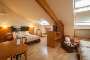 sypialnia na poddaszu z łóżkiem i biurkiem oraz pokój w obiekcie Hotel Bonavida w mieście Canillo