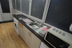 a small kitchen with a sink and a stove at Garsoniera in Cluj-Napoca