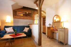 a living room with a blue couch and a kitchen at Almliesl Gruppenhaus PUCH-625 in Puchenstuben