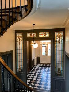 a hallway with a staircase and stained glass windows at VILLA VARENTIA in Villers-Bretonneux