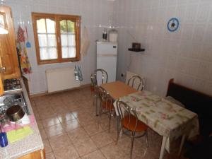 La cuisine est équipée d'une table, de chaises et d'un réfrigérateur. dans l'établissement Vila Busteni DORA, locatie superba strada Grivitei 36, à Buşteni