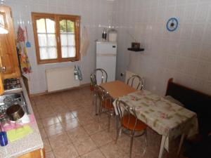 a kitchen with a table and chairs and a refrigerator at Vila Busteni DORA, locatie superba strada Grivitei 36 in Buşteni