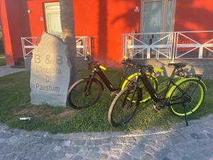 zwei Fahrräder, die neben einem Schild vor einem Gebäude geparkt sind in der Unterkunft L'Incanto di Paestum in Capaccio-Paestum
