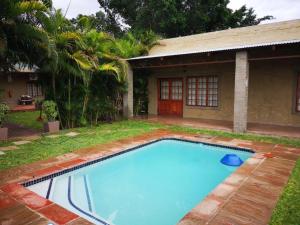 a large blue swimming pool in front of a house at Lifestyle Corner Guesthouse in Musina