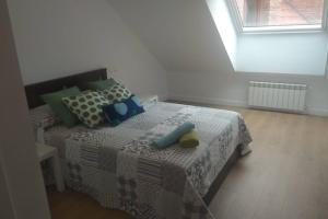 1 dormitorio con 1 cama con almohadas verdes y azules en PLAZA CENTRAL CANGAS DE Onís, en Cangas de Onís