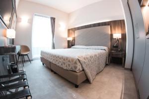 um quarto com uma cama, uma mesa e uma cadeira em Hotel Kuma em San Giuseppe