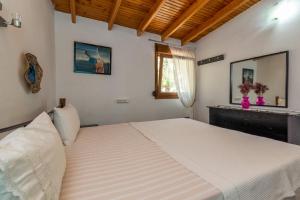 a large white bed in a bedroom with a window at Front Beach House in Skala Kallirakhis