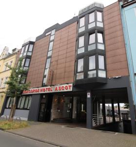 ein braunes Gebäude mit einem Schild, auf dem gespielte Hotelbestände angezeigt werden in der Unterkunft Concorde Hotel Ascot in Düsseldorf