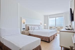 a hotel room with two beds and a window at Melia Sitges in Sitges