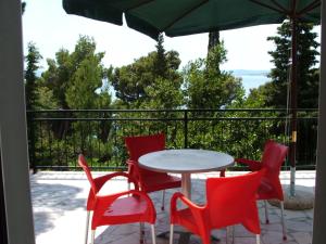 un patio con mesa, sillas y sombrilla en Apartments Stari Pavle, en Brela
