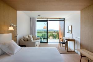 a hotel room with a bed and a living room at Empordà Golf Resort in Torroella de Montgrí +37 photos