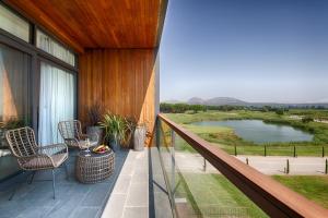 a balcony with chairs and a view of a lake at Empordà Golf Resort in Torroella de Montgrí