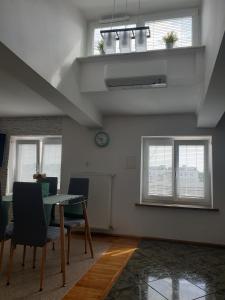 Un comedor con una mesa y dos ventanas. en Marszałkowska Apartament RM HOUSE, en Varsovia