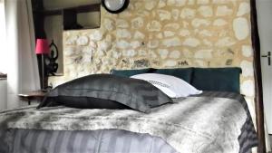 a bedroom with a bed with a stone wall at Chambre d'Hôtes Etretat in Les Loges