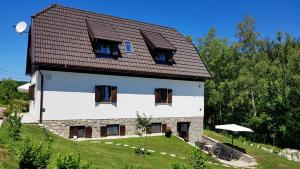 une grande maison blanche avec un toit marron dans l'établissement B&B Plitvice Lakes Villa Mija, à Plitvica selo