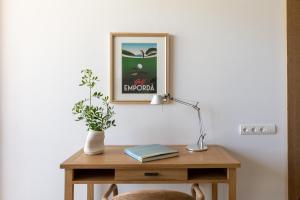 a table with a lamp and a picture on the wall at Empordà Golf Resort in Torroella de Montgrí