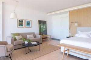 a hotel room with a bed and a couch at Empordà Golf Resort in Torroella de Montgrí