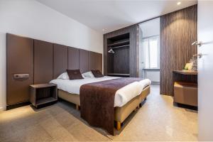 um quarto de hotel com uma cama grande e uma janela em Hotel Central em Bruges