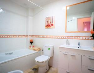 uma casa de banho com um WC, um lavatório e uma banheira em Bungalow Los Dolses em Orihuela