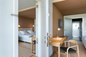 a hotel room with a bed and a desk and a table at Empordà Golf Resort in Torroella de Montgrí