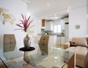 een woonkamer met een glazen tafel met een plant in een vaas bij Bungalow Los Dolses in Orihuela