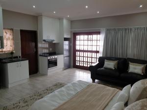 un soggiorno con divano e una cucina di Pongola Road Self Catering Accommodation a Uitenhage