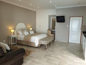 Pongola Road Self Catering Accommodation في Uitenhage: غرفة نوم بسرير وتلفزيون على جدار