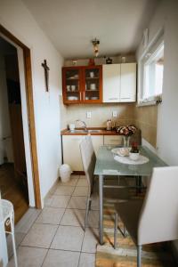 a kitchen with a table and chairs in a room at Lavanda in Vukovar