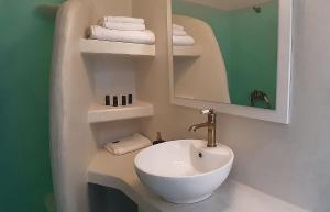 een badkamer met een wastafel, een spiegel en handdoeken bij Bella Vista in Panteli