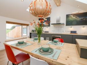 a kitchen with a wooden dining table with chairs at Pen Chy in Helston