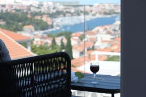 a glass of wine sitting on a table on a balcony at Dubrovnik Icy Guest House in Dubrovnik