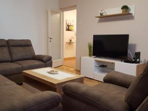 a living room with two couches and a flat screen tv at Harmony apartment in Rijeka