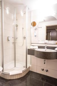 ein Bad mit einer Dusche und einem Waschbecken in der Unterkunft Hotel Restaurant Ennen in Norderney