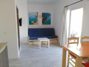 un soggiorno con divano blu e tavolo di Apartamentos Arcadio a El Arenal